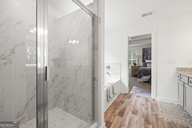 full bath featuring a stall shower, wood finished floors, ensuite bathroom, vanity, and a bath