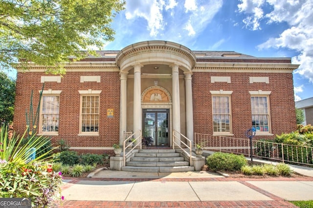 view of front of property with brick siding and french doors