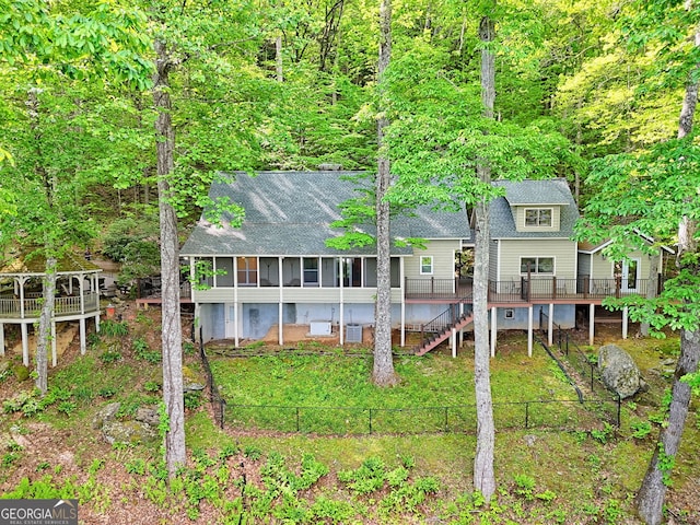 back of property with fence, a deck, stairs, and roof with shingles