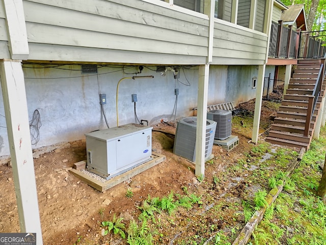 exterior view of stairs, central air condition unit, and a power unit