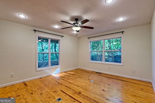 empty room with plenty of natural light, a ceiling fan, recessed lighting, and baseboards