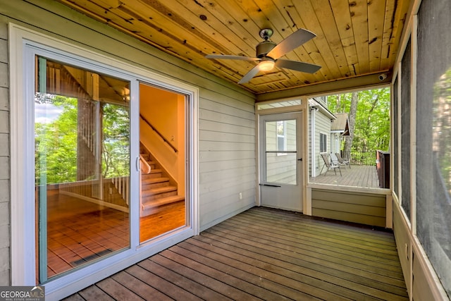 unfurnished sunroom featuring ceiling fan