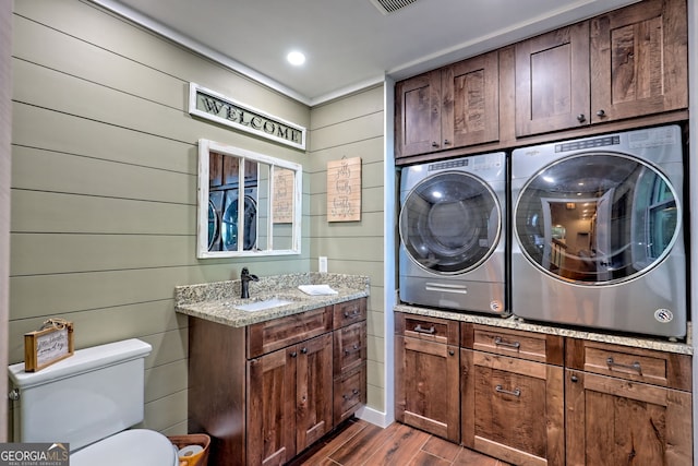 washroom featuring separate washer and dryer and dark wood finished floors