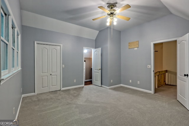 unfurnished bedroom featuring vaulted ceiling, carpet floors, baseboards, and ceiling fan
