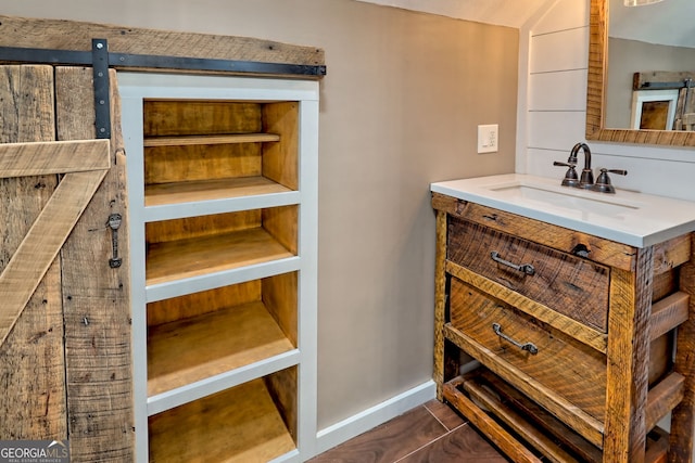 bathroom featuring vanity, baseboards, and vaulted ceiling