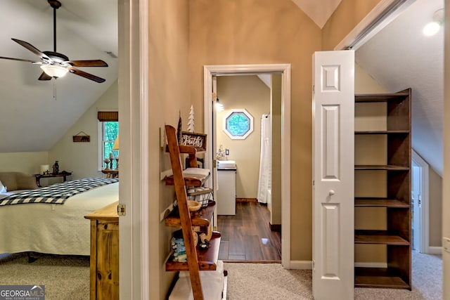 bedroom featuring lofted ceiling, baseboards, and wood finished floors