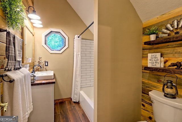 full bathroom with wood finished floors, toilet, vanity, lofted ceiling, and shower / bath combo