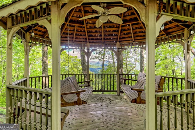 wooden terrace with ceiling fan, a gazebo, and a mountain view