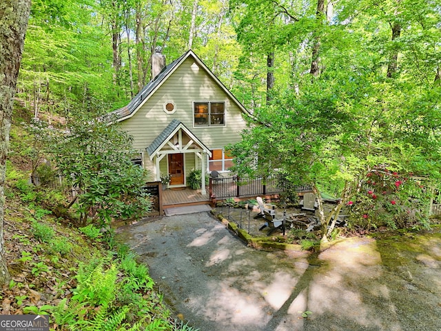 rustic home with a chimney and a wooden deck