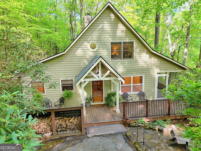 rear view of house with a chimney and a deck