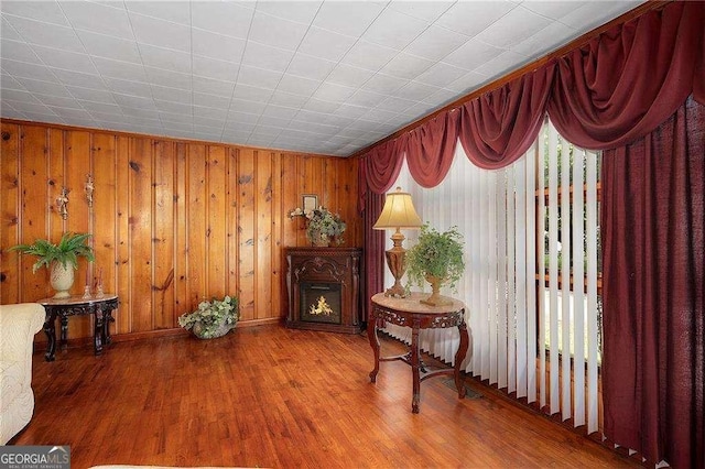 413 New Town Rd NE, Calhoun, GA 30701 - living area with wood finished floors, a lit fireplace, baseboards, and wooden walls