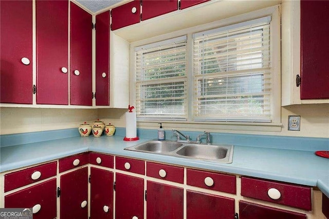 413 New Town Rd NE, Calhoun, GA 30701 - kitchen featuring red cabinetry, a sink, and light countertops