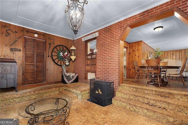 413 New Town Rd NE, Calhoun, GA 30701 - dining space featuring a wood stove, wood walls, ornamental molding, and a chandelier