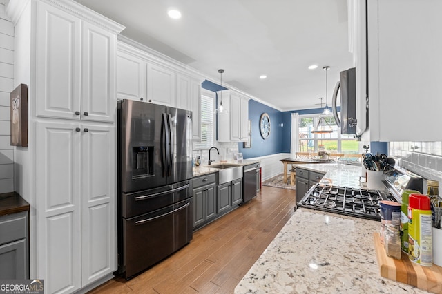 58 Gables Way, Newnan, GA 30265 - kitchen featuring stainless steel appliances, a sink, light wood finished floors, white cabinetry, and recessed lighting