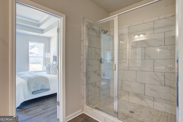 ensuite bathroom with a shower stall, wood finished floors, and baseboards