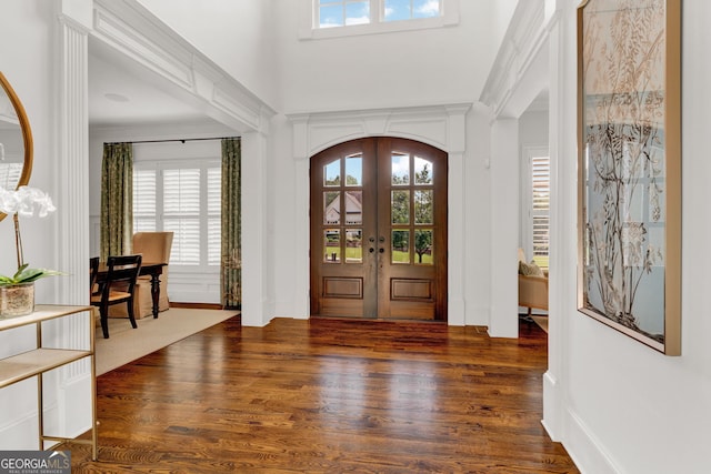 entrance foyer featuring french doors, plenty of natural light, and wood finished floors