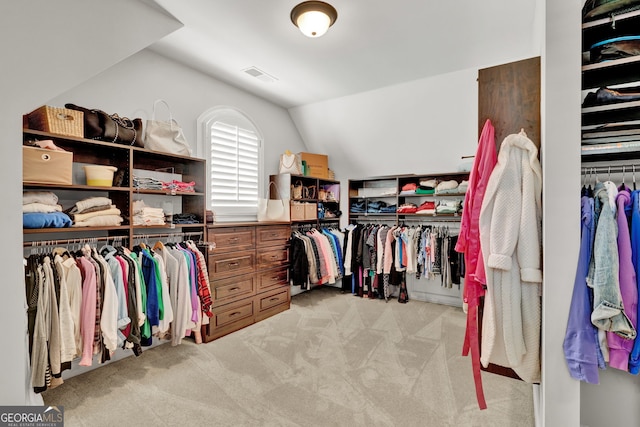 spacious closet with vaulted ceiling and light carpet