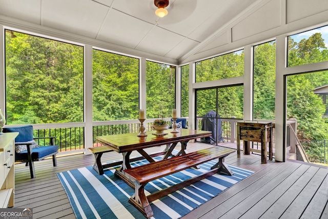 sunroom / solarium with plenty of natural light, vaulted ceiling, and outdoor dining space