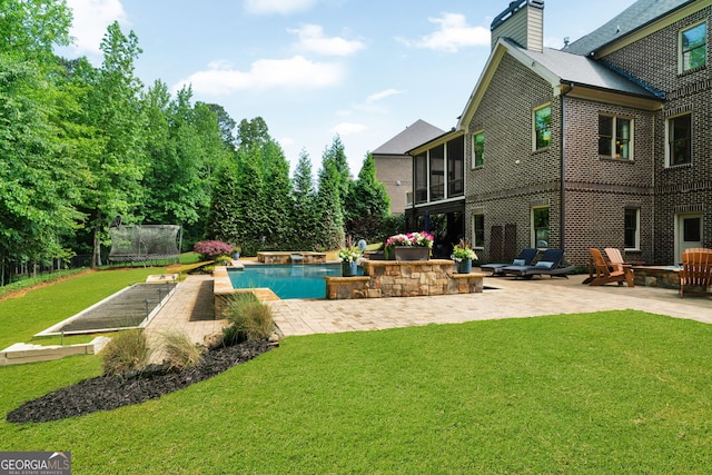 swimming pool featuring a patio, a yard, a sunroom, and a trampoline