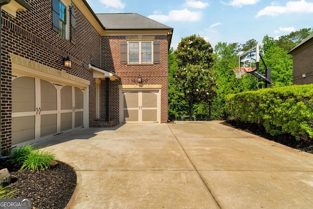 view of home's exterior featuring brick siding and concrete driveway