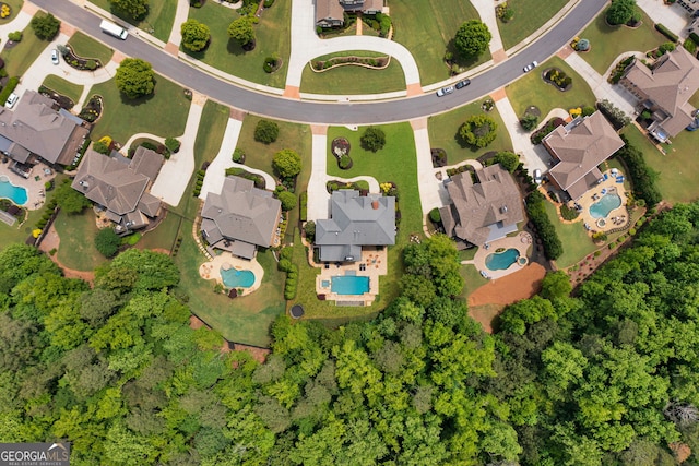 aerial view of property's location featuring a pool area and nearby suburban area