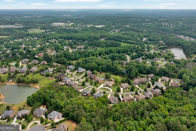 aerial overview of property's location with a nearby body of water, nearby suburban area, and a forest
