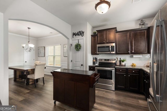 3406 Pennington Dr, Lithonia, GA 30038 - kitchen featuring appliances with stainless steel finishes, dark brown cabinets, backsplash, dark wood-style floors, and crown molding