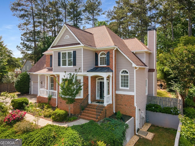 view of front of property featuring fence, a chimney, brick siding, roof with shingles, and a garage