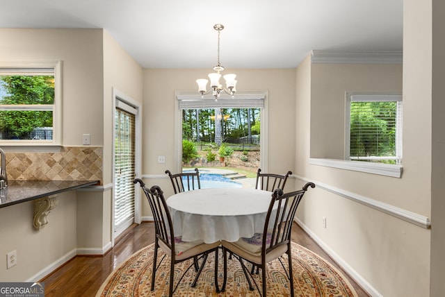 dining space with a chandelier, healthy amount of natural light, and wood finished floors