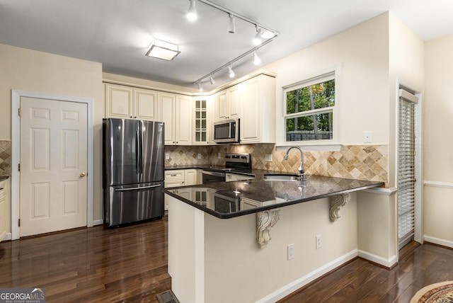 825 Yosemite Dr, Suwanee, GA 30024 - kitchen with appliances with stainless steel finishes, a sink, dark wood-style floors, a peninsula, and glass insert cabinets
