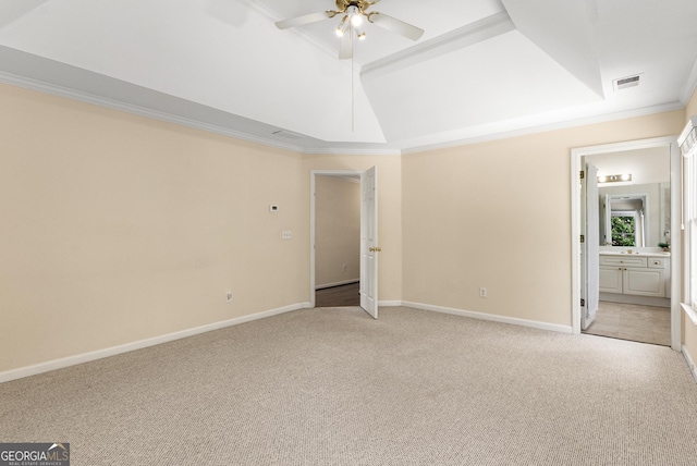 unfurnished bedroom with light colored carpet, ornamental molding, baseboards, ensuite bath, and a ceiling fan