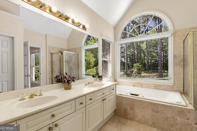 full bath featuring plenty of natural light, lofted ceiling, a shower stall, double vanity, and a garden tub
