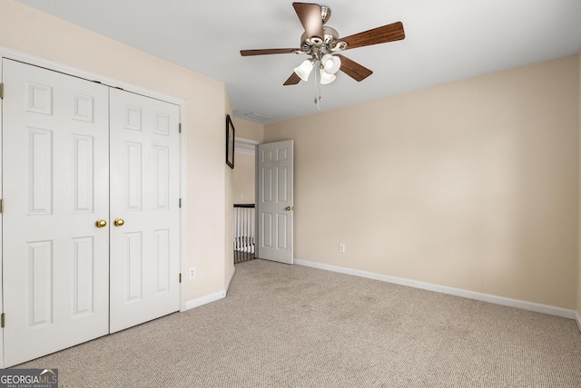 unfurnished bedroom with carpet flooring, a closet, baseboards, and ceiling fan