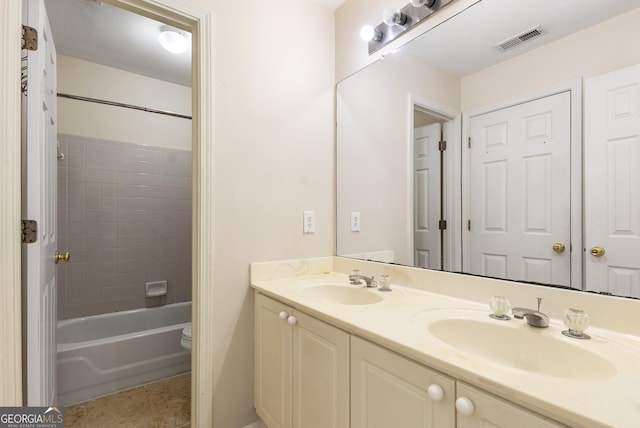 full bath with double vanity, toilet, and washtub / shower combination
