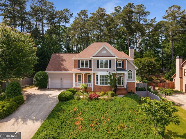 view of front of property featuring fence, brick siding, driveway, a chimney, and a garage