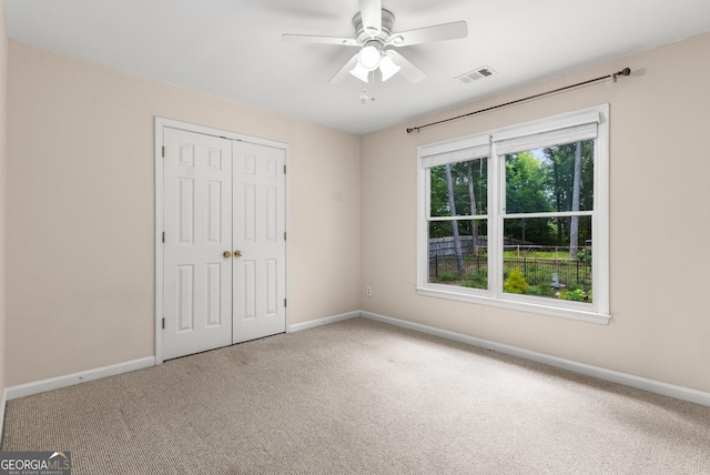 unfurnished bedroom featuring baseboards, carpet flooring, a closet, and ceiling fan