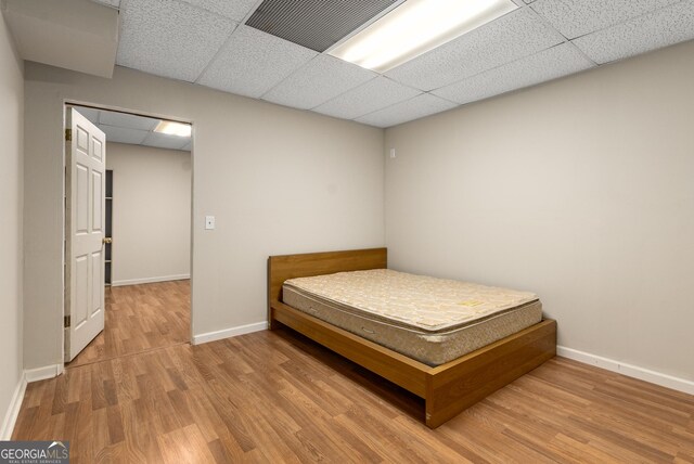 825 Yosemite Dr, Suwanee, GA 30024 - bedroom featuring a drop ceiling, wood finished floors, and baseboards