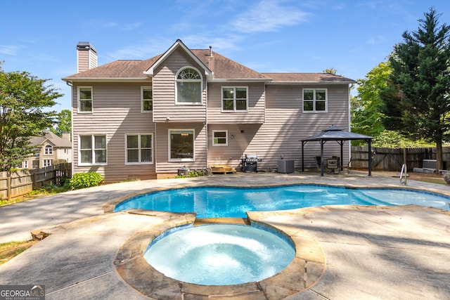 view of swimming pool with a gazebo, a patio, a fenced backyard, central AC, and a pool with connected hot tub