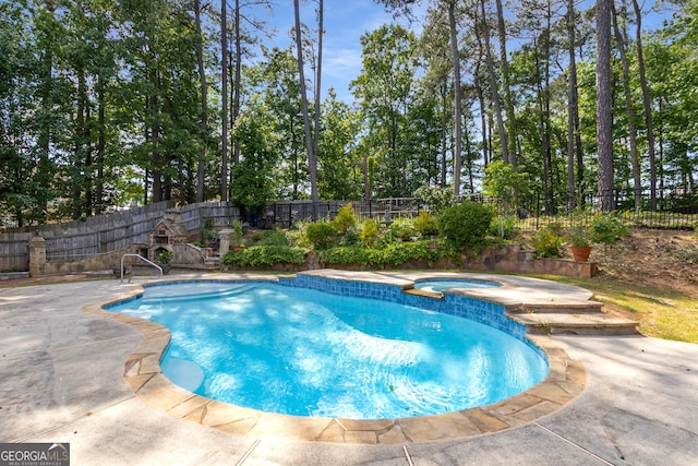 view of swimming pool featuring a fenced backyard, a pool with connected hot tub, and a patio area
