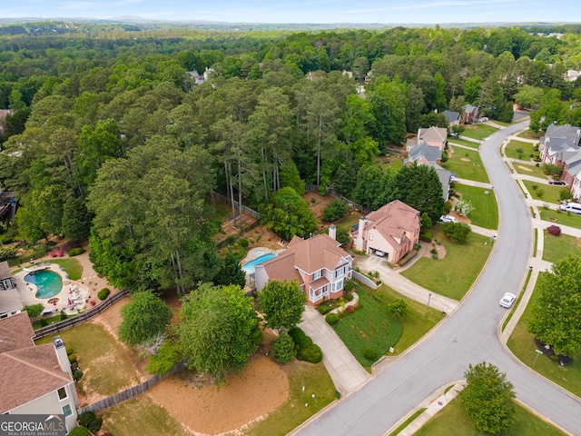 view of property location with a heavily wooded area and a pool