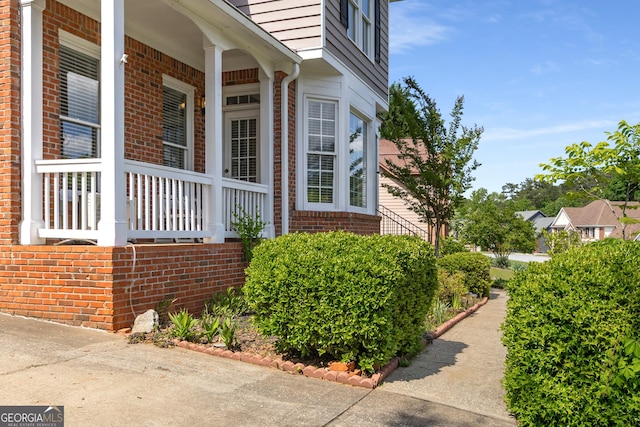 view of property exterior featuring brick siding and a porch