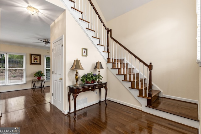 stairway featuring ceiling fan, wood finished floors, baseboards, and crown molding
