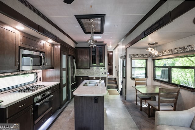 43 Tip Top Cir, Cleveland, GA 30528 - kitchen with appliances with stainless steel finishes, a sink, a kitchen island with sink, light countertops, and decorative backsplash