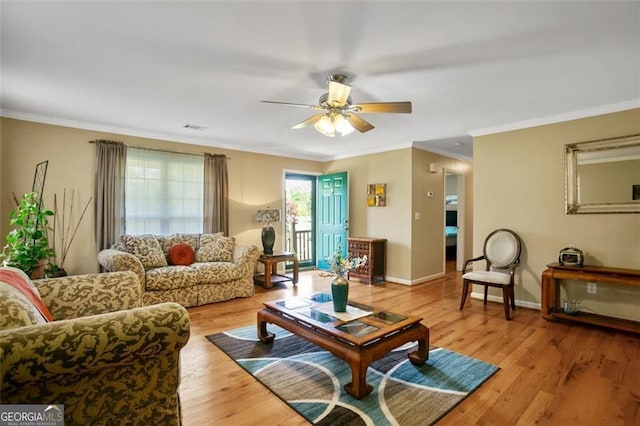 living area featuring ceiling fan, crown molding, light wood finished floors, and baseboards