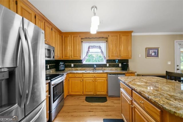 kitchen with stainless steel appliances, a sink, backsplash, light stone counters, and crown molding