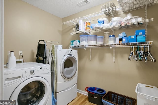 washroom with separate washer and dryer, wood finished floors, and baseboards