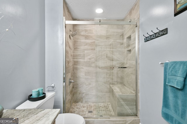 bathroom featuring toilet, a textured ceiling, and a stall shower