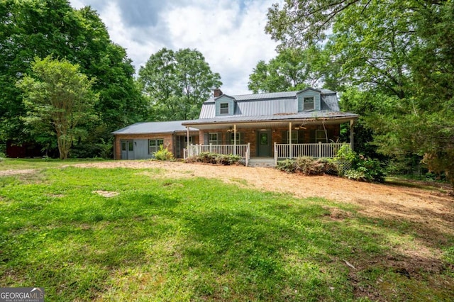 farmhouse with a chimney, metal roof, a porch, and a front yard