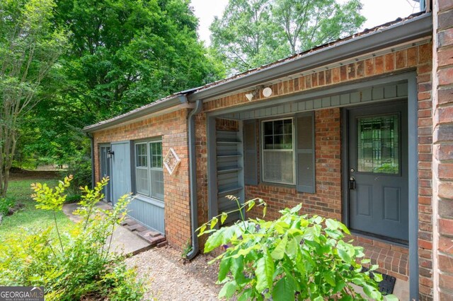 doorway to property featuring brick siding