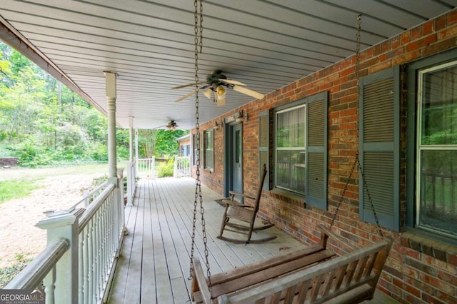 wooden terrace featuring a porch and a ceiling fan